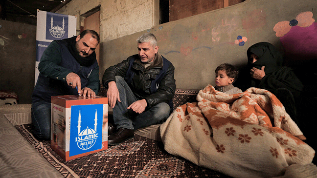 family in gaza receiving winter aid from islamic relief gaza team