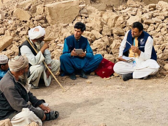 islamic relief staff in afghanistan sat with a group of men affected by the recent earthquakes