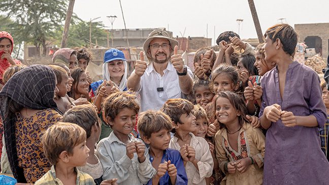 MP Afzal Khan with a group of children in Pakistan, visiting home rebuilding projects with Islamic Relief