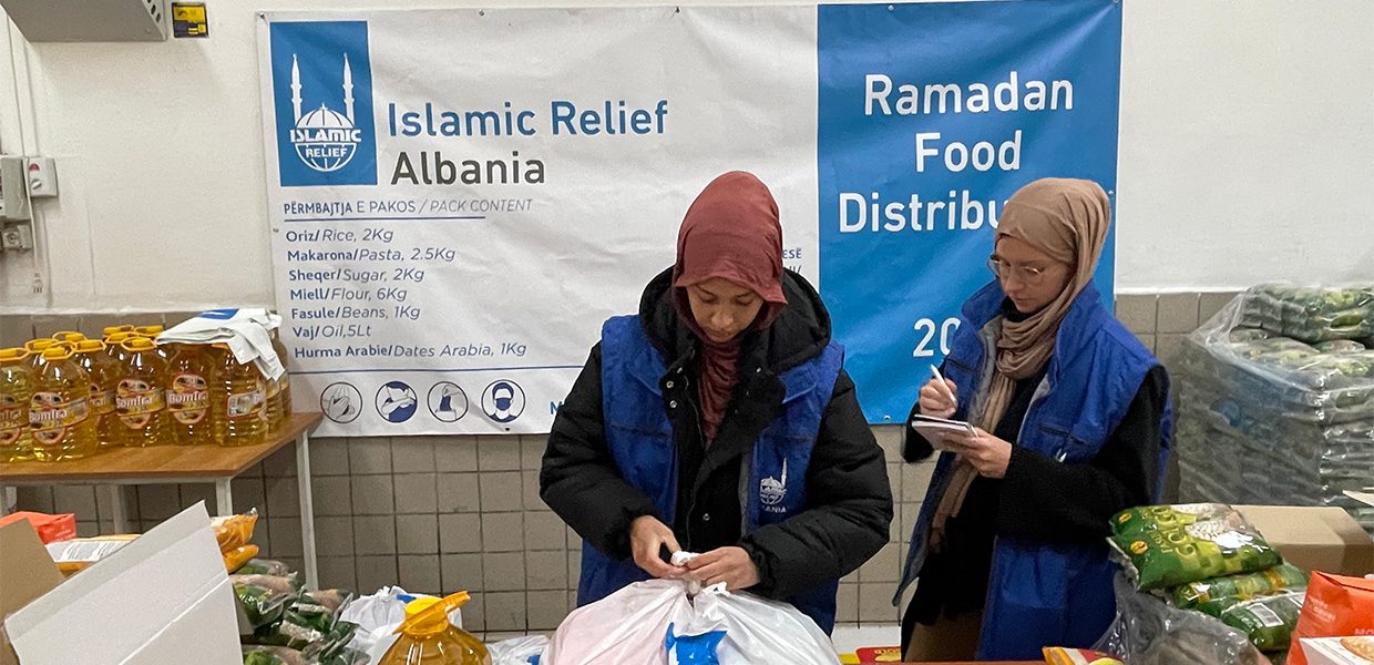 Islamic Relief staff member tying bag containing food items