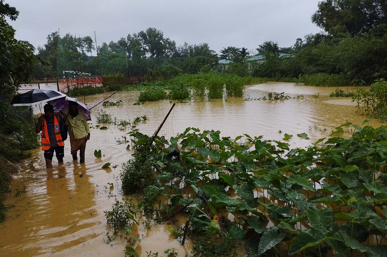 islamic relief volunteer supporting elderly man during flash floods in bangladesh islamic relief