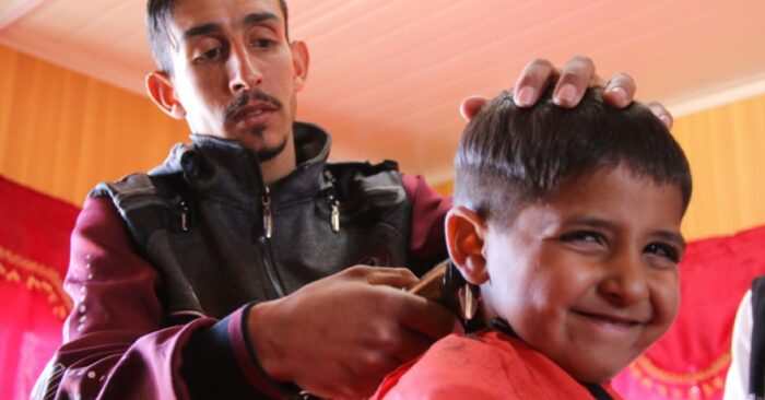 a man trimming a young boys hair barber shop