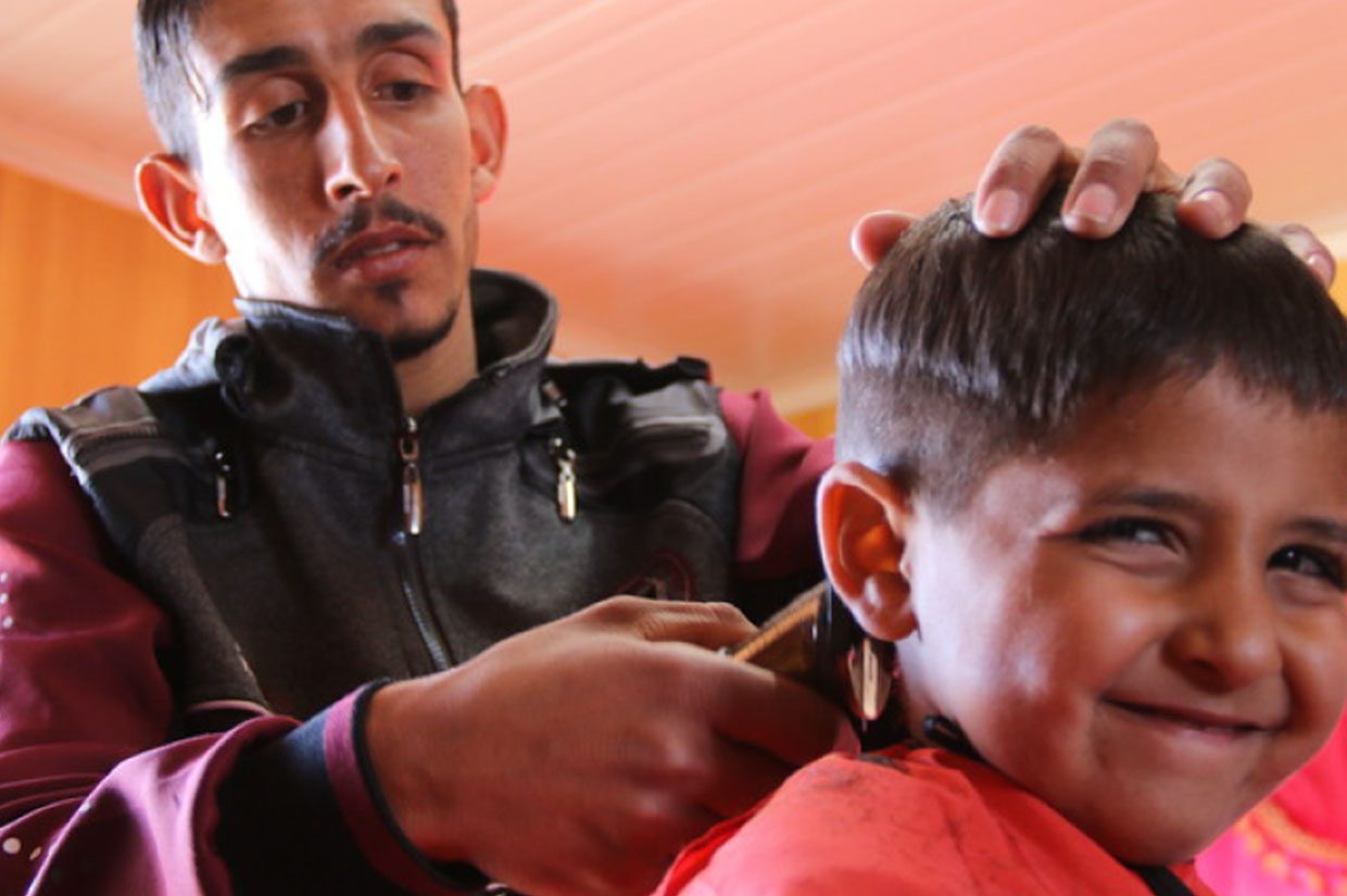 a man trimming a young boys hair barber shop