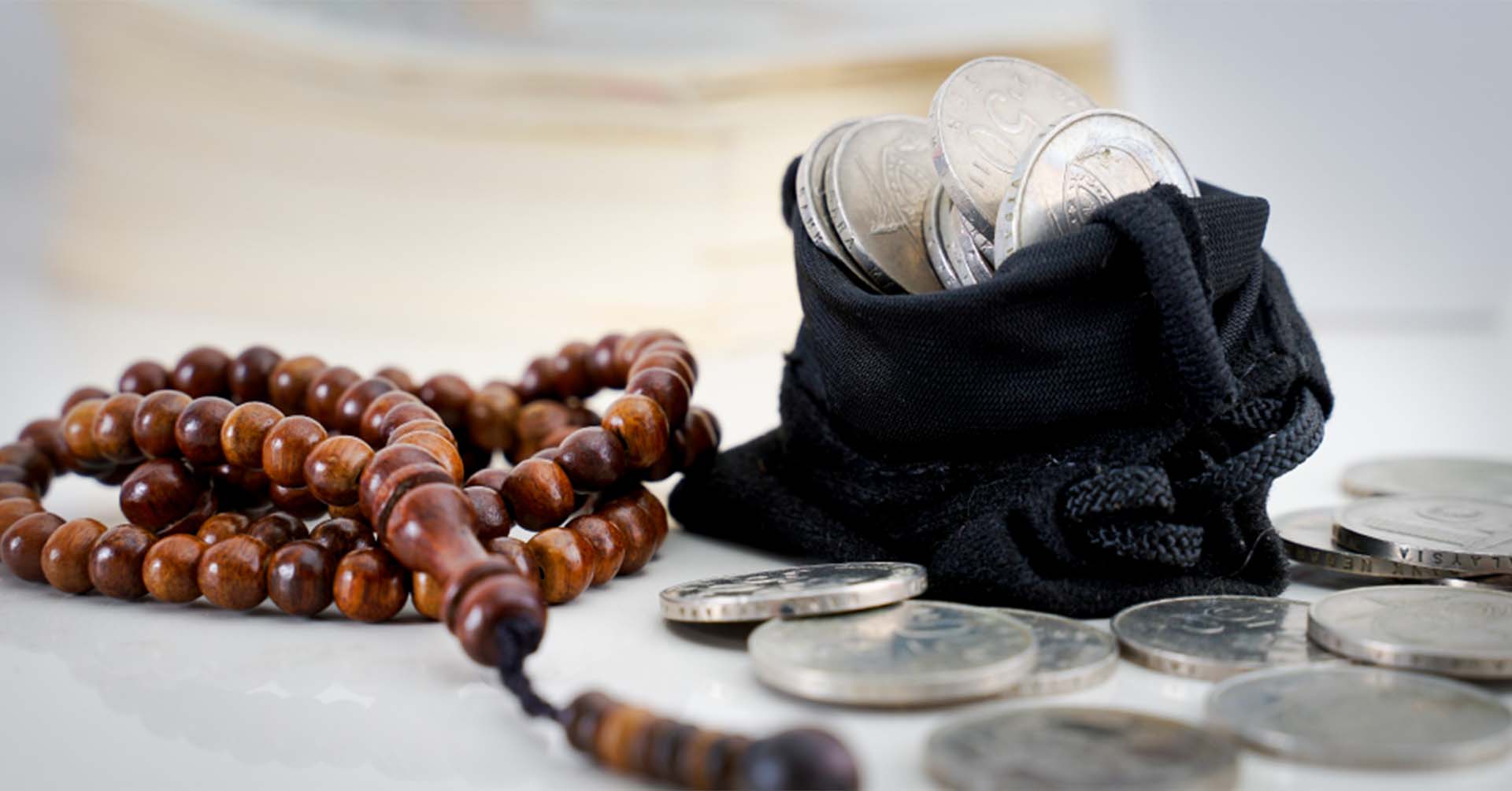 brown prayer beads (tasbih) and black pouch of silver coins charity in islam