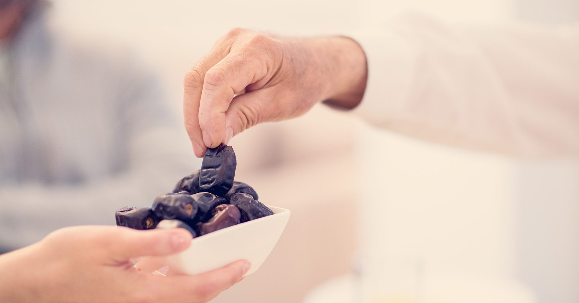 hand picking from a bowl of dates day of ashura fasting