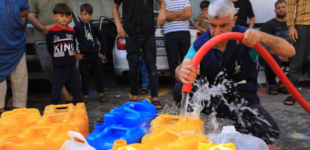 islamic relief teams in gaza filling water containers with clean water to distribute to affected people