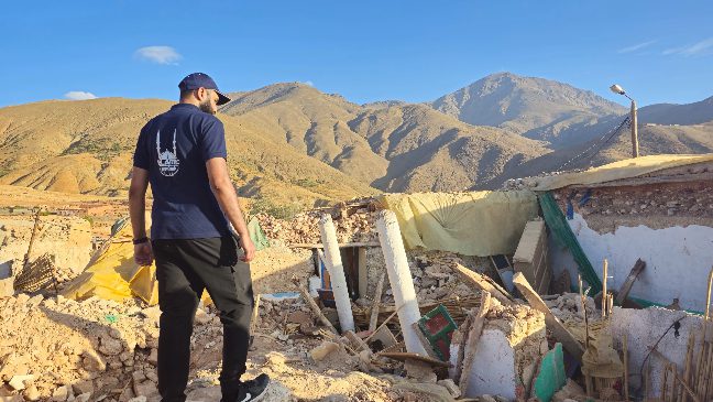 islamic relief staff standing amongst rubble after the earthquake in morocco