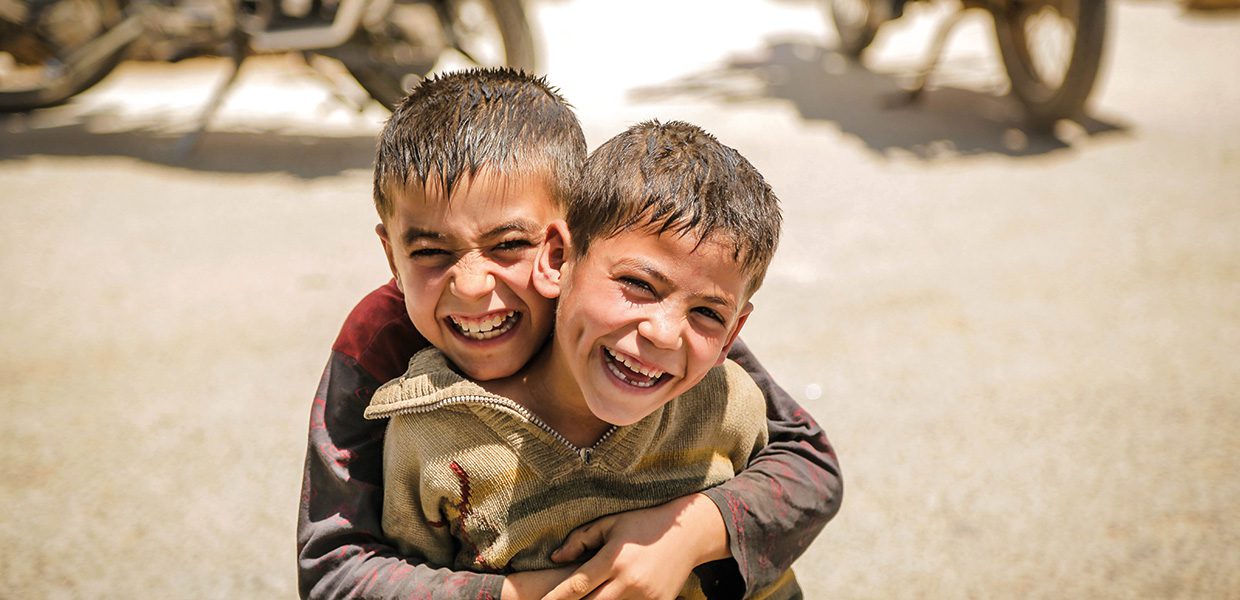 Two boys hugging and smiling