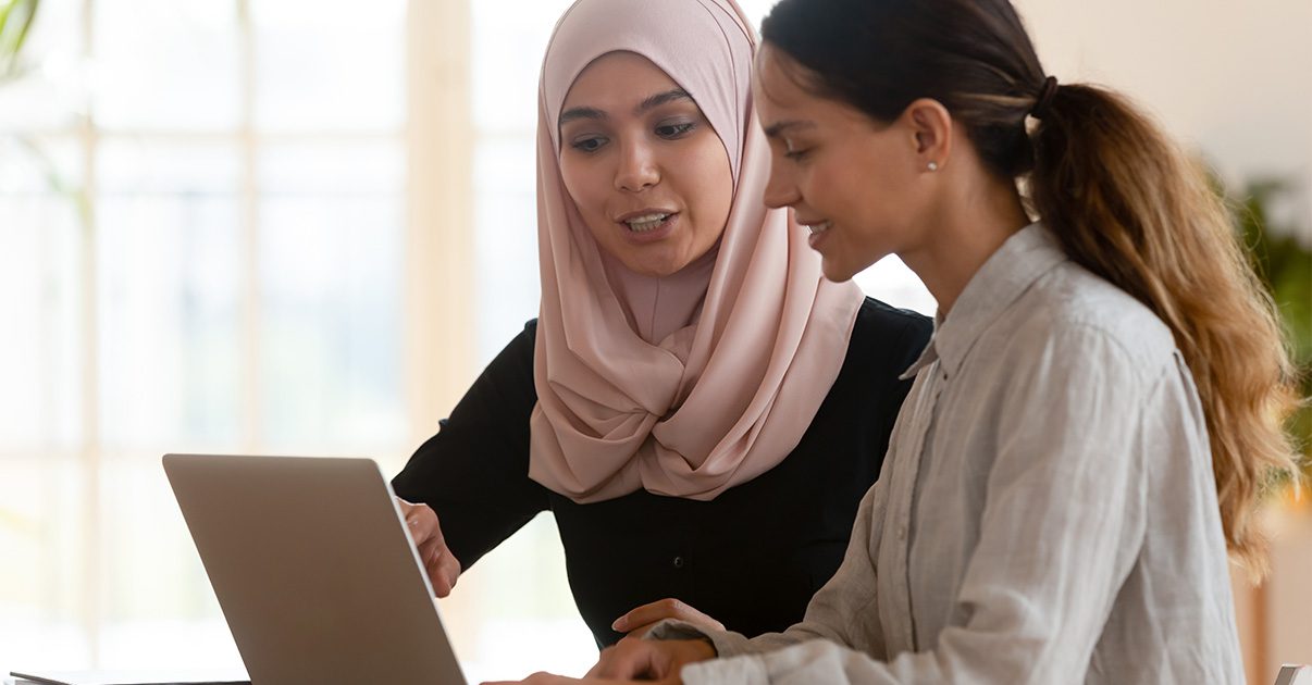 Two women looking at a laptop screen.