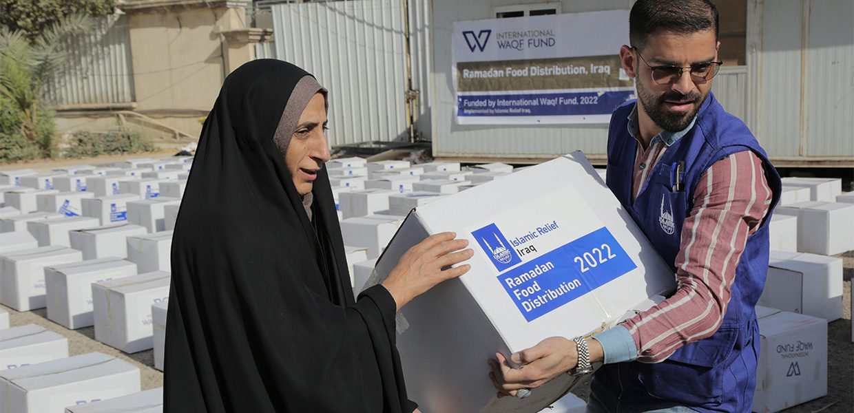 Lady receiving Ramadan food package from Islamic Relief member