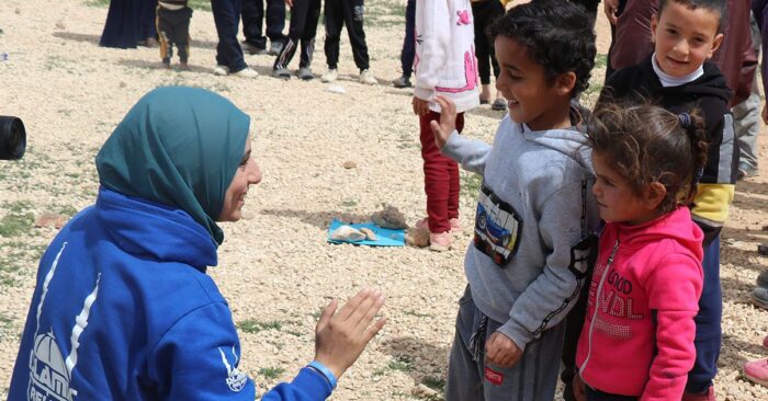 Islamic Relief staff member talking to children