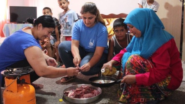 While the wife of the head of the family and his sister together with the IR staff prepare the meat for cooking