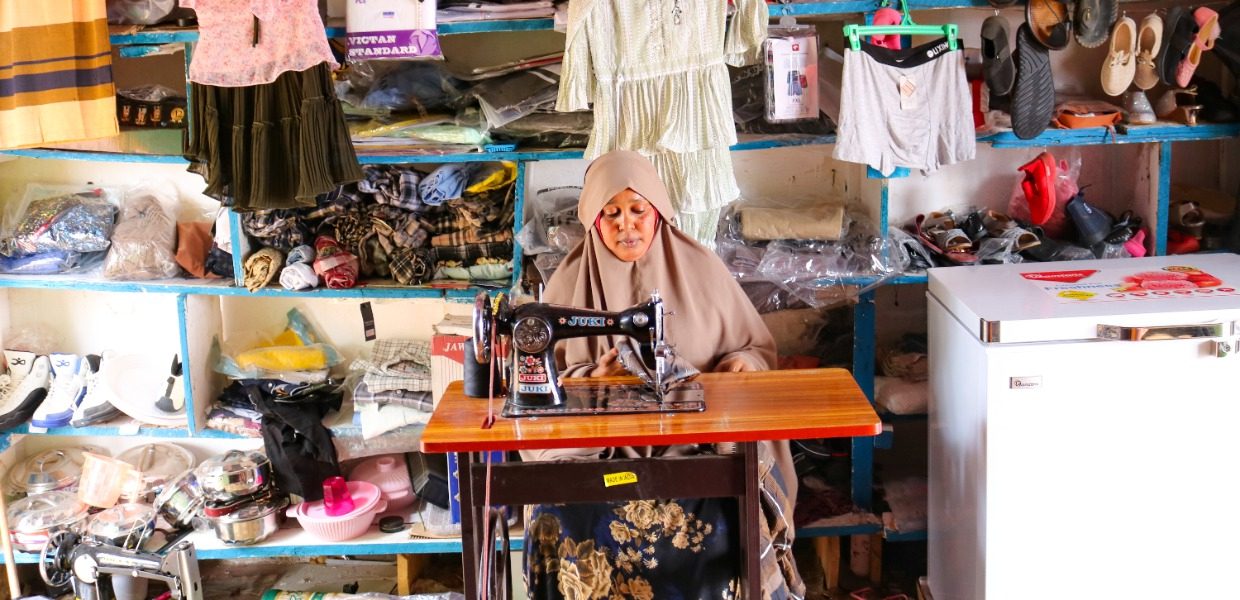 Raha Abdi, a 34-year-old single mother is part of the Iskufilan Women Group, sat infront of her sewing machine in their shop