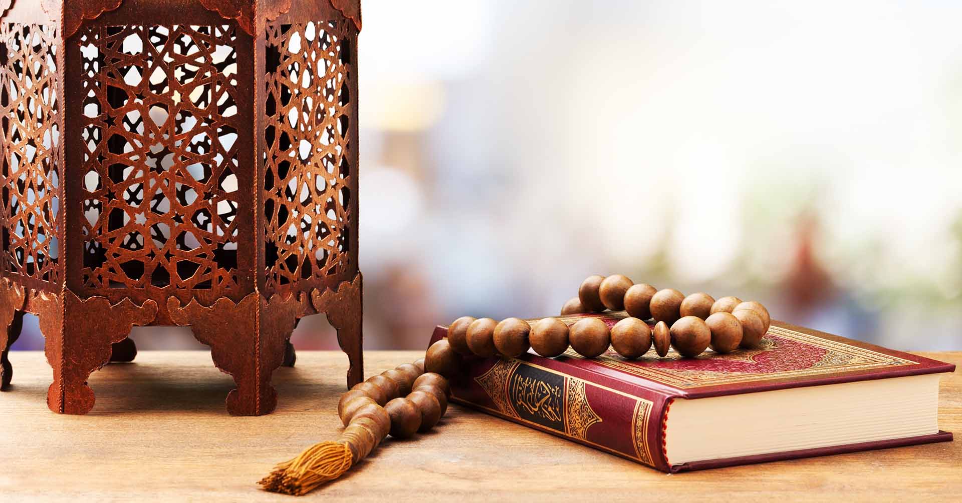 brown tasbih prayer beads resting on red quran knowledge base