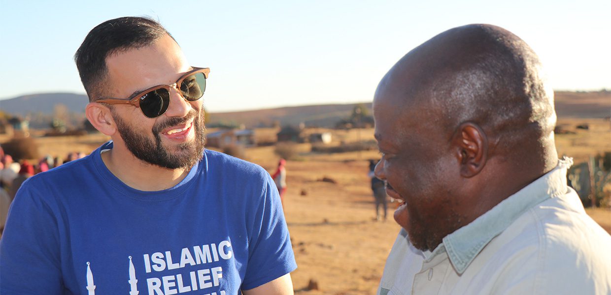 Islamic Relief staff member talking to and smiling at a beneficiary.