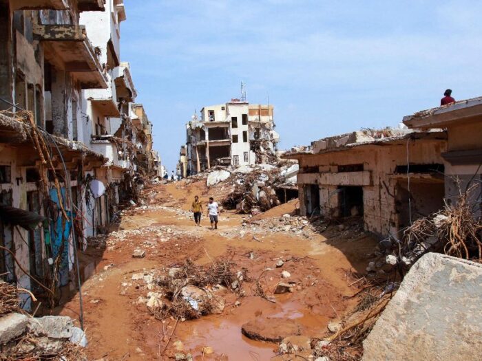 a street in libya impacted by the floods with mud, buildings collapsed and rubble