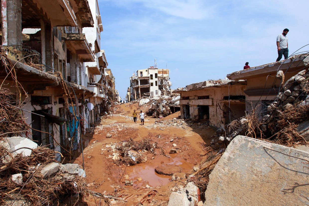 a street in libya impacted by the floods with mud, buildings collapsed and rubble