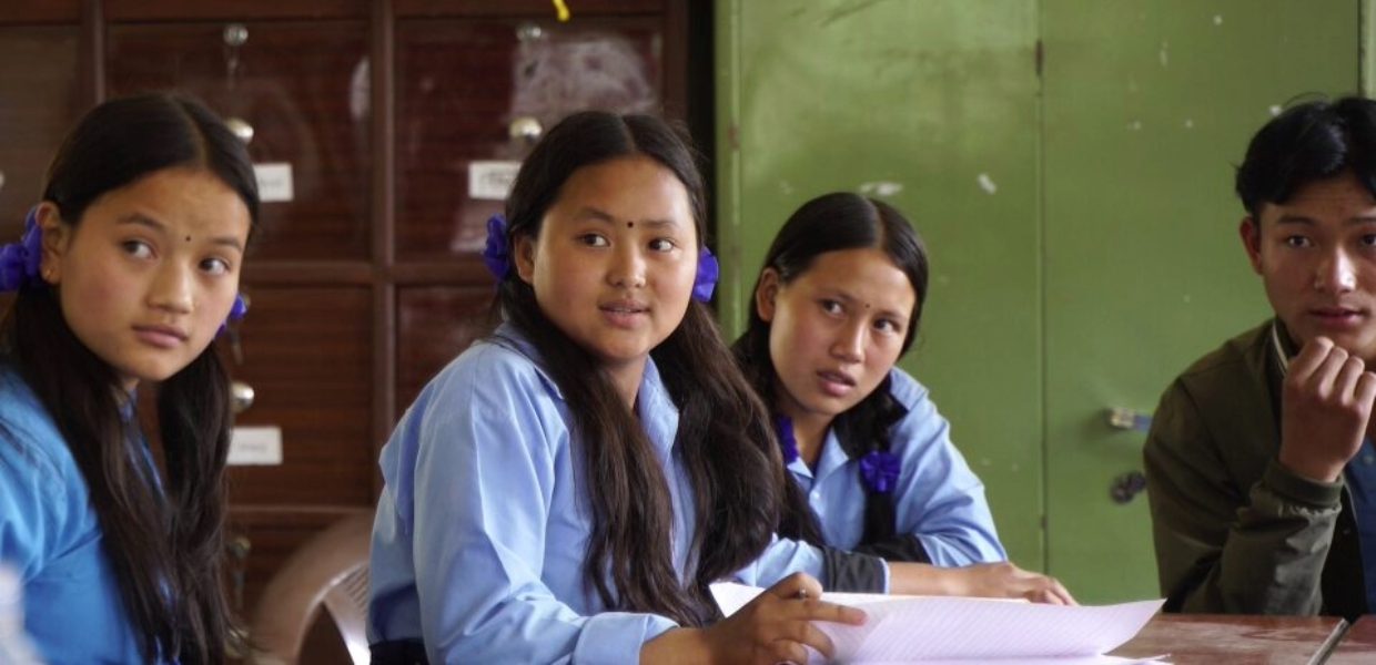 a young girl from nepal sat in the classroom with her peers