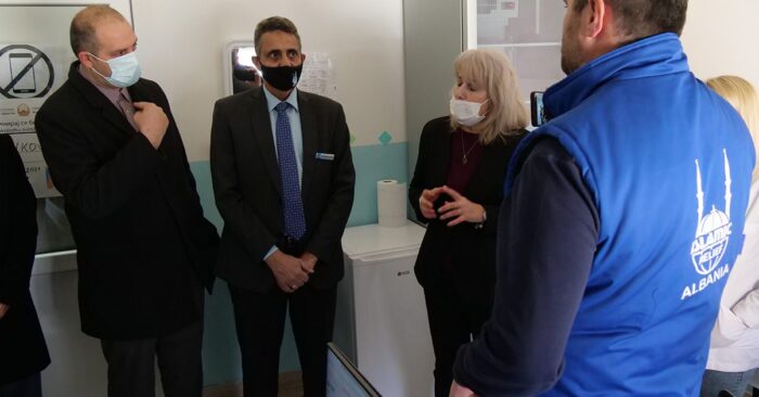 Islamic Relief staff member stood with government officials in hospital