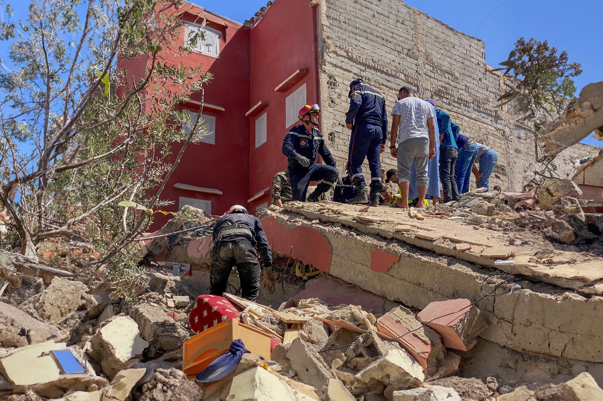 a group of people standing on a collapsed building morocco earthquake