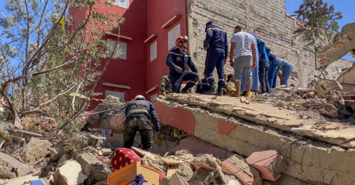 a group of people standing on a collapsed building morocco earthquake