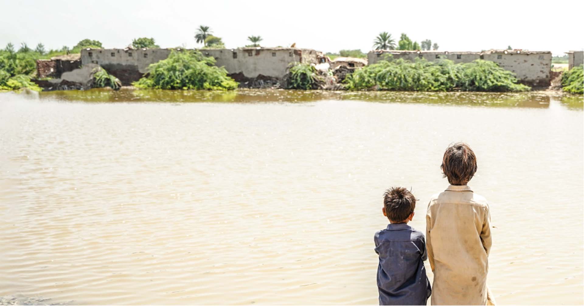 two young boys in pakistan overlooking flooding