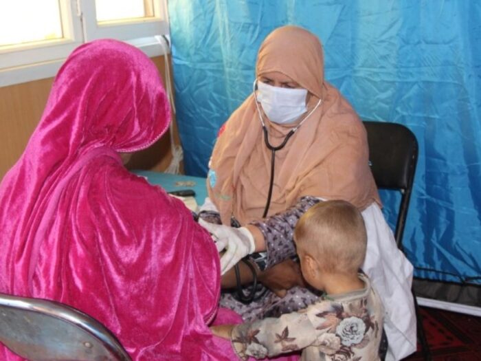 an afghan returnee receiving medicine and checks from a pharmacist in afghanistan