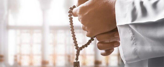 man doing dhikr using prayer beads (tasbih) prayer timetables