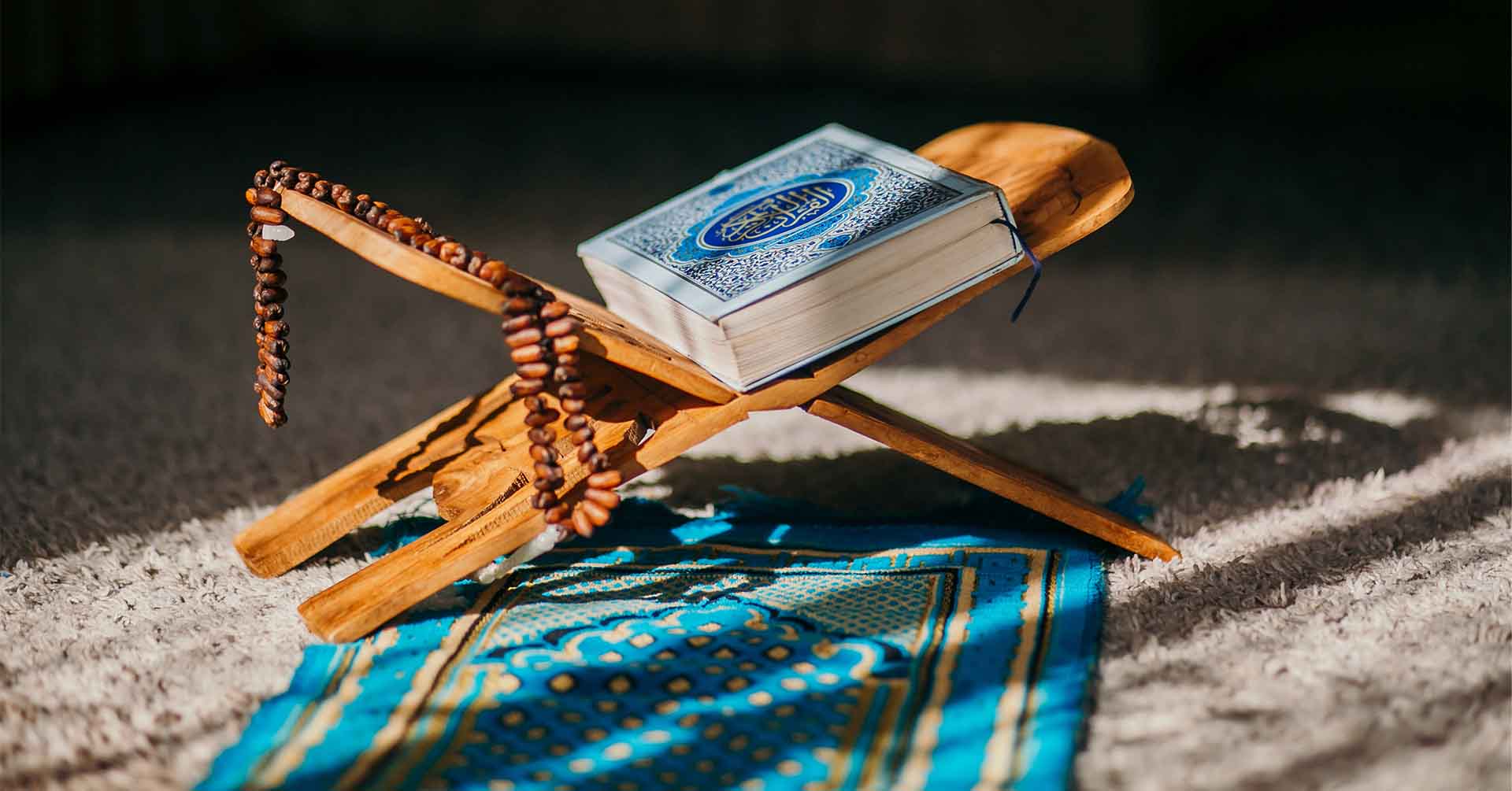 quran and prayer beads (tasbih) on quran stand on blue prayer (salah) mat prayer timetables newcastle