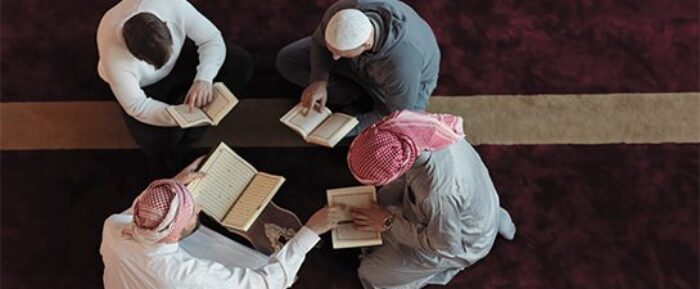 men gathered in a masjid reading quran together prayer timetables