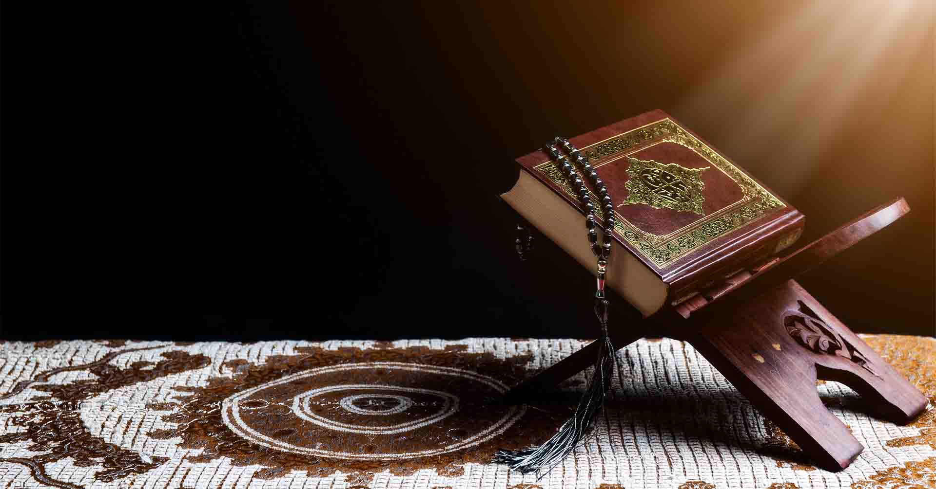 quran and prayer beads (tasbih) on prayer mat for salah prayer timetables peterborough