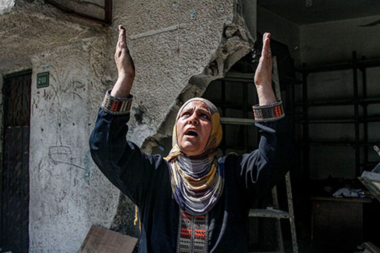 palestinian women raising her hands up in prayer pray for palestine gaza