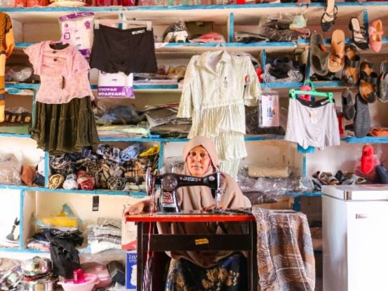 Raha Abdi, a 34-year-old single mother is part of the Iskufilan Women Group, sat infront of her sewing machine in their shop