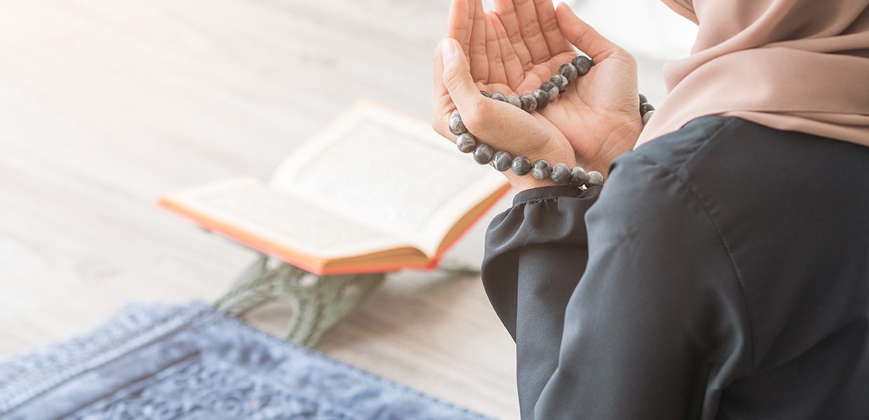 Women praying, holding a tasbih, which a copy of the Holy Qur'an in front of her. tips for ramadan duas for dhul hijjah