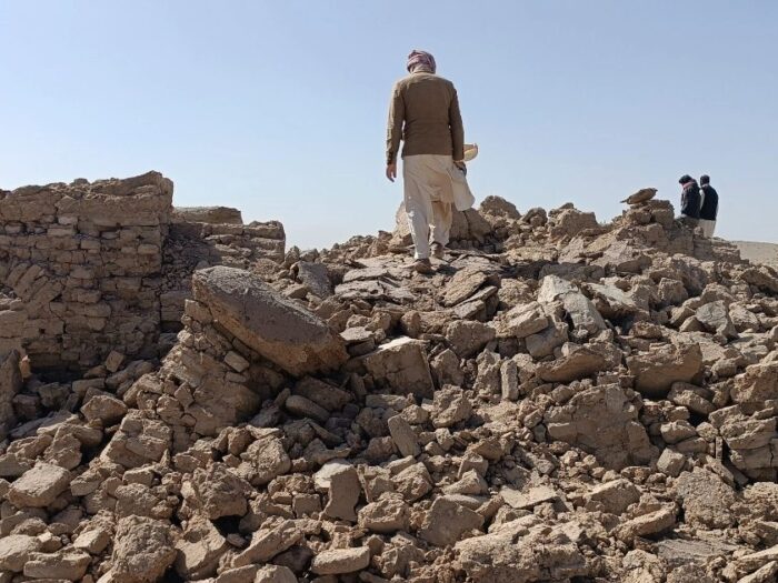 a man standing on top of a pile of debris following earthquakes in afghanistan