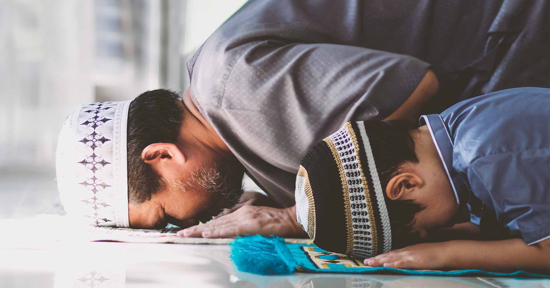 two people (older man and young boy) praying salah in sujood position edinburgh prayer times