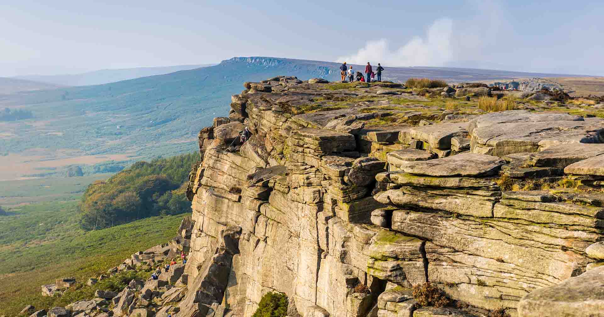 a group of people standing on stanage edge in the UK