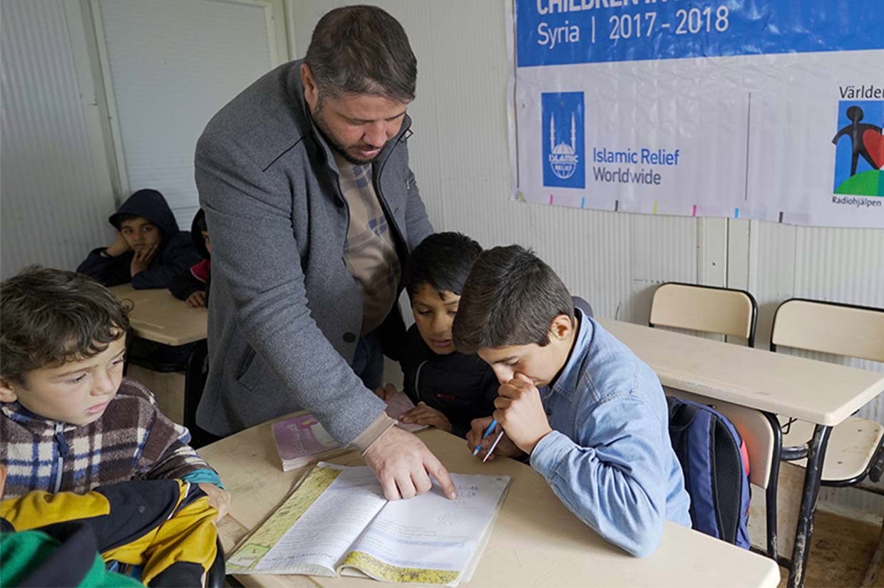 teacher helping a student in syria