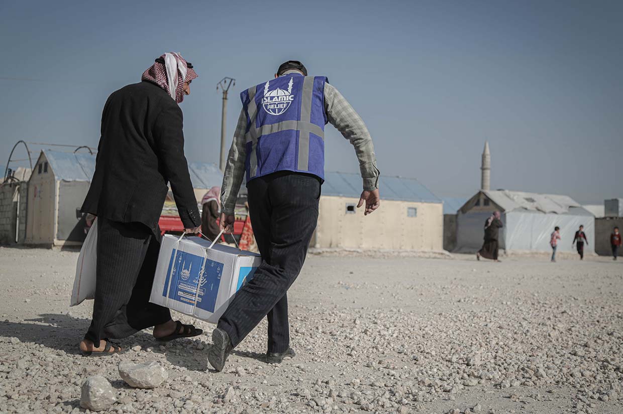 two men holding a box together ramadan distribution syria your zakat is our amanah islamic relief