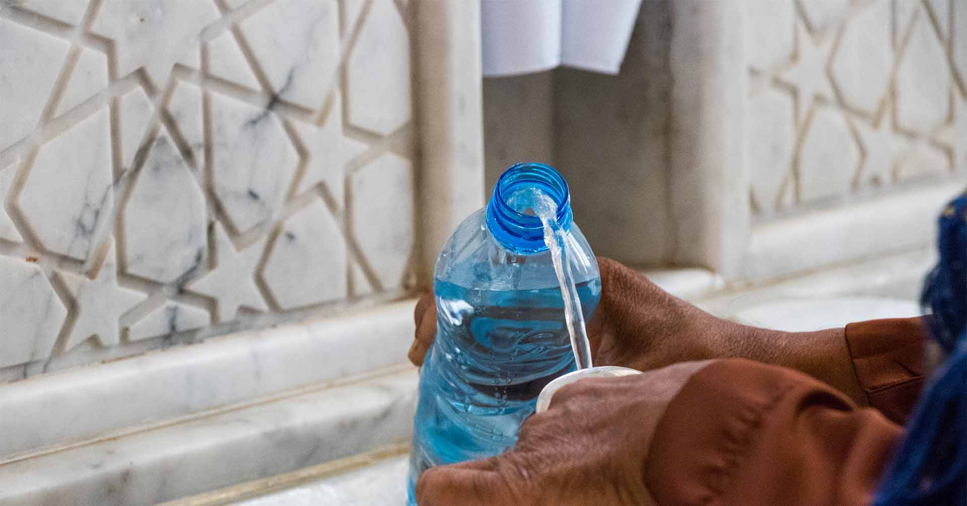 zamzam water being poured into a bottle at masjid al haram